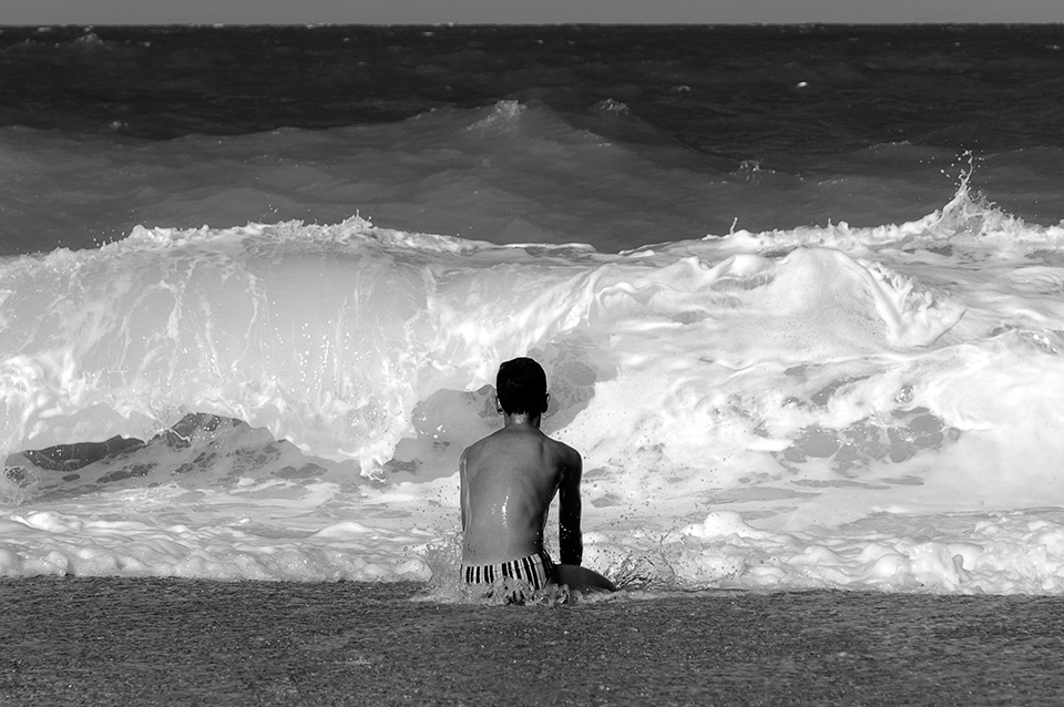Ragazzo guarda le onde del mare